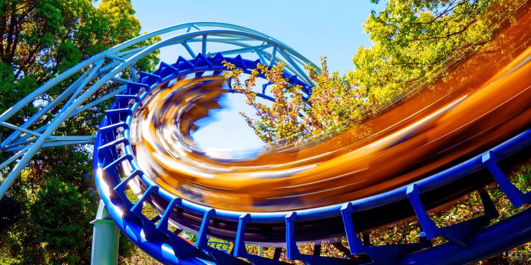 IAAPA-Expo-Orlando Twisting blue roller coaster with yellow speeding cars